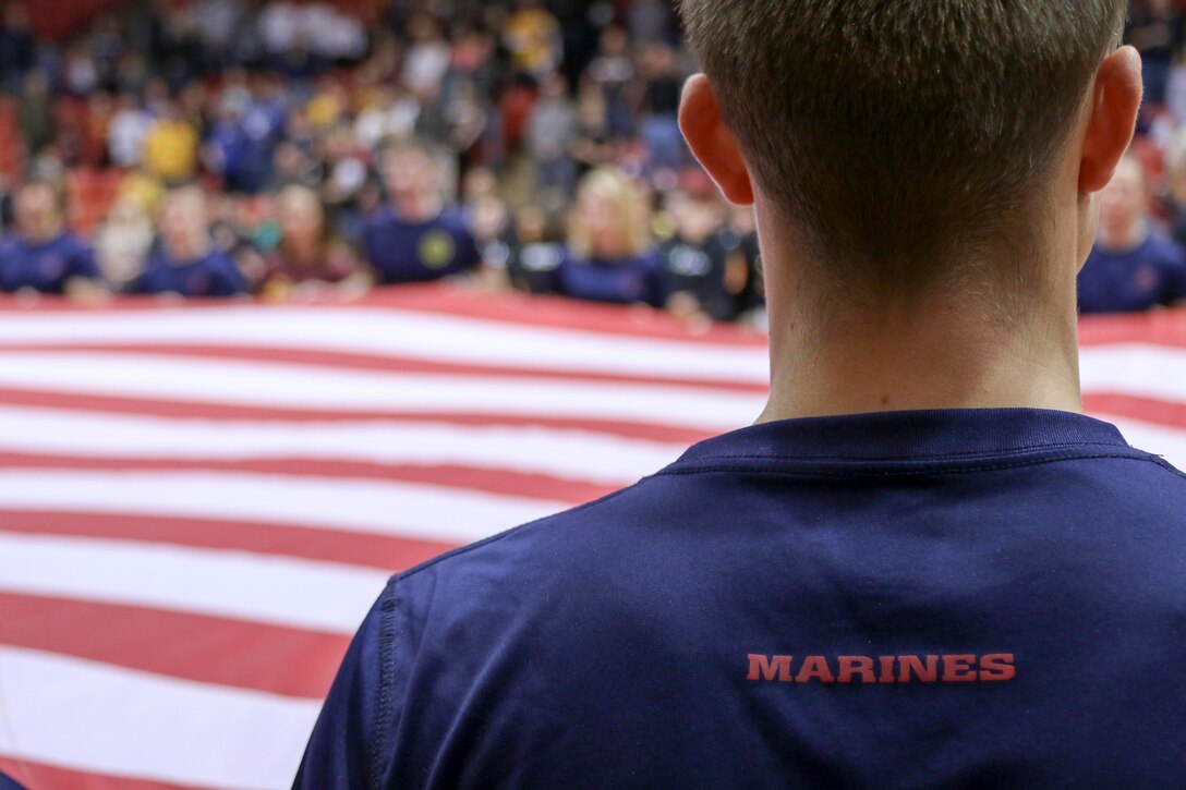 Marine Corps recruiters and poolees hold a large American Flag during the National Anthem before a Canton Charge basketball game March 3, 2017 in Canton, Ohio. The poolees reaffirmed their commitment to joining the Marine Corps and earning the title Marine before a sold out crowd at a military appreciation game. The poolees are part of Marine Corps Recruiting Station Cleveland and will ship to Marine Corps Recruit Depot Parris Island, South Carolina within the next 365 days. (U.S. Marine Corps photo by Sgt. Stephen D Himes/Released)