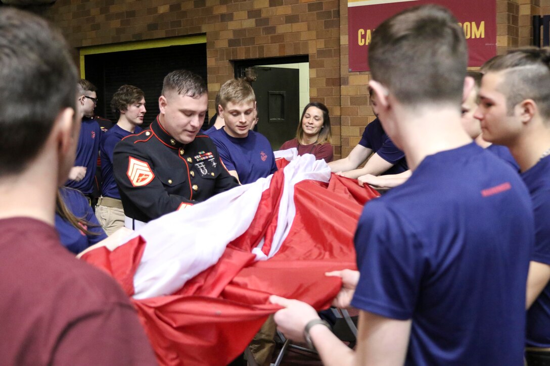 Marine Corps recruiters and their poolees prepare to carry a large American Flag onto the Canton Charge basketball court for the National Anthem March 3, 2017. The Canton Charge held a military appreciation night to thank service members and local responders. Before the game 20 Marine Corps poolees were sworn-in at center court by Maj Shawn Meier, commanding officer of Marine Corps Recruiting Station Cleveland. (U.S. Marine Corps photo by Sgt. Stephen D. Himes/Released)