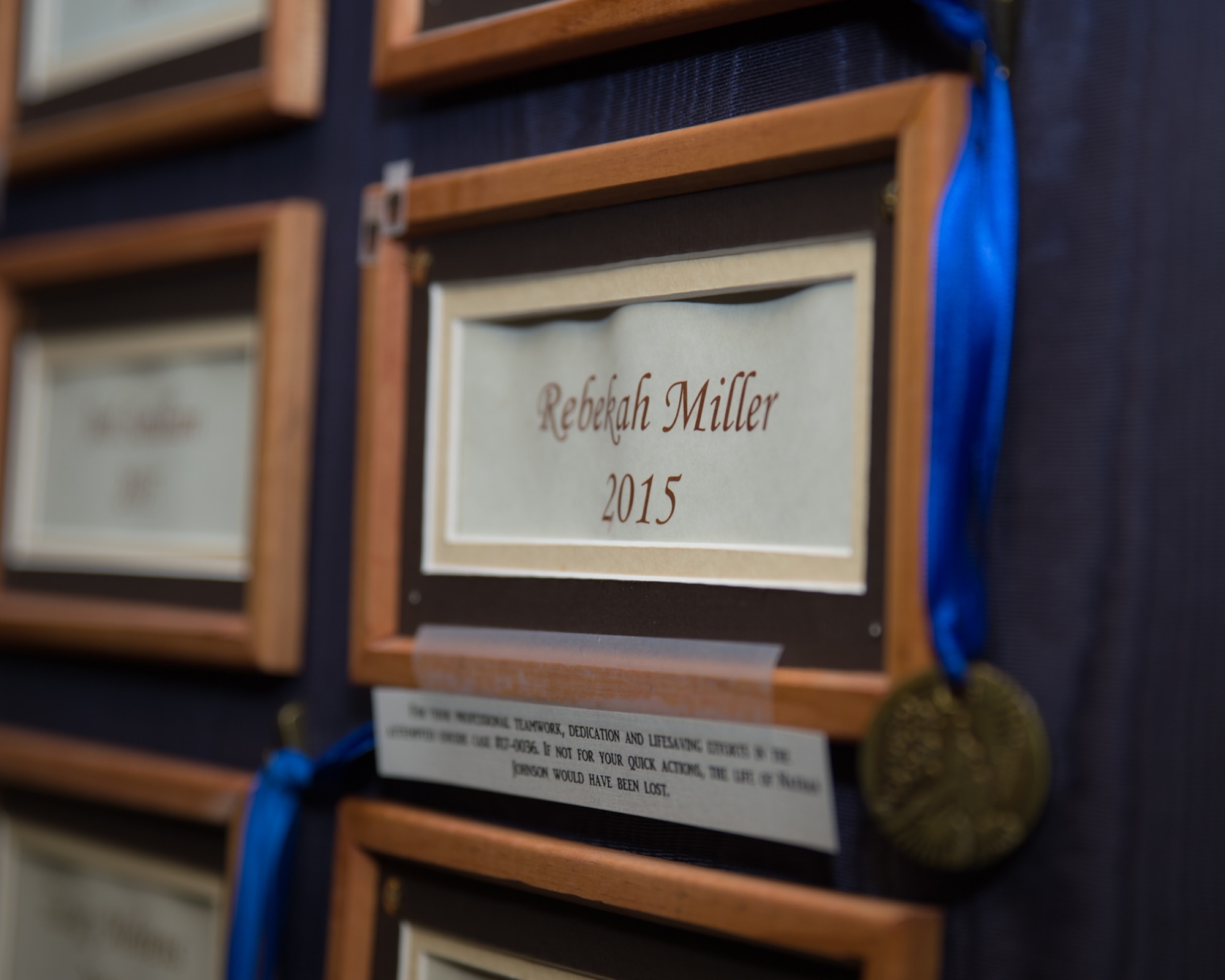 A blue ribbon is draped across a wooden frame surrounding the name Rebekah Miller which is on a board in the Torrington police department, Mar. 10, 2017 in Torrington, Wyoming. Staff Sgt. Rebekah Miller is a member of the Wyoming Air National Guard and has for served six years. She is currently assigned as a command post specialist with the 153rd Airlift Wing. Miller has also been an officer with the Torrington police department for two years. (U.S. Air National Guard photo by Senior Master Sgt. Charles Delano/released)