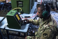 Sgt. Kenneth G. Elliott programs a Crew Access Unit (CAU) inside the 301st Maneuver Enhancement Brigade tactical command post (TAC) on Joint Base Lewis-McChord, Washington, March 11, 2017. Soldiers from the 301st Maneuver Enhancement Brigade went through a series of maneuver and mobility exercises to ensure deployment readiness and demonstrate the brigade’s ability to command and control in a tactical environment. (U.S. Army Reserve photo by Spc. Sean F. Harding/Released).