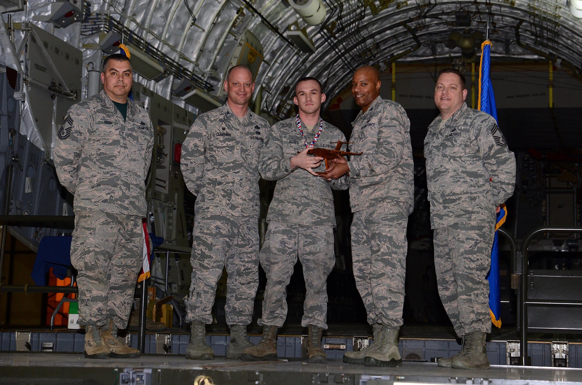 Leadership from the 62nd Maintenance Group and 627th Air Base Group award Senior Airman Matthew Schieb (center), 627th Logistics Readiness Squadron, the Top Knucklebuster award during Logfest 2017 March 24, 2017, at Joint Base Lewis-McChord, Wash. Unlike traditional award nominees, Knucklebuster nominees are nominated by their peers for work performance and overall character. (U.S. Air Force photo/Senior Airman Jacob Jimenez)  
