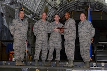 Leadership from the 62nd Maintenance Group and 627th Air Base Group award Senior Airman Matthew Schieb (center), 627th Logistics Readiness Squadron, the Top Knucklebuster award during Logfest 2017 March 24, 2017, at Joint Base Lewis-McChord, Wash. Unlike traditional award nominees, Knucklebuster nominees are nominated by their peers for work performance and overall character. (U.S. Air Force photo/Senior Airman Jacob Jimenez)  