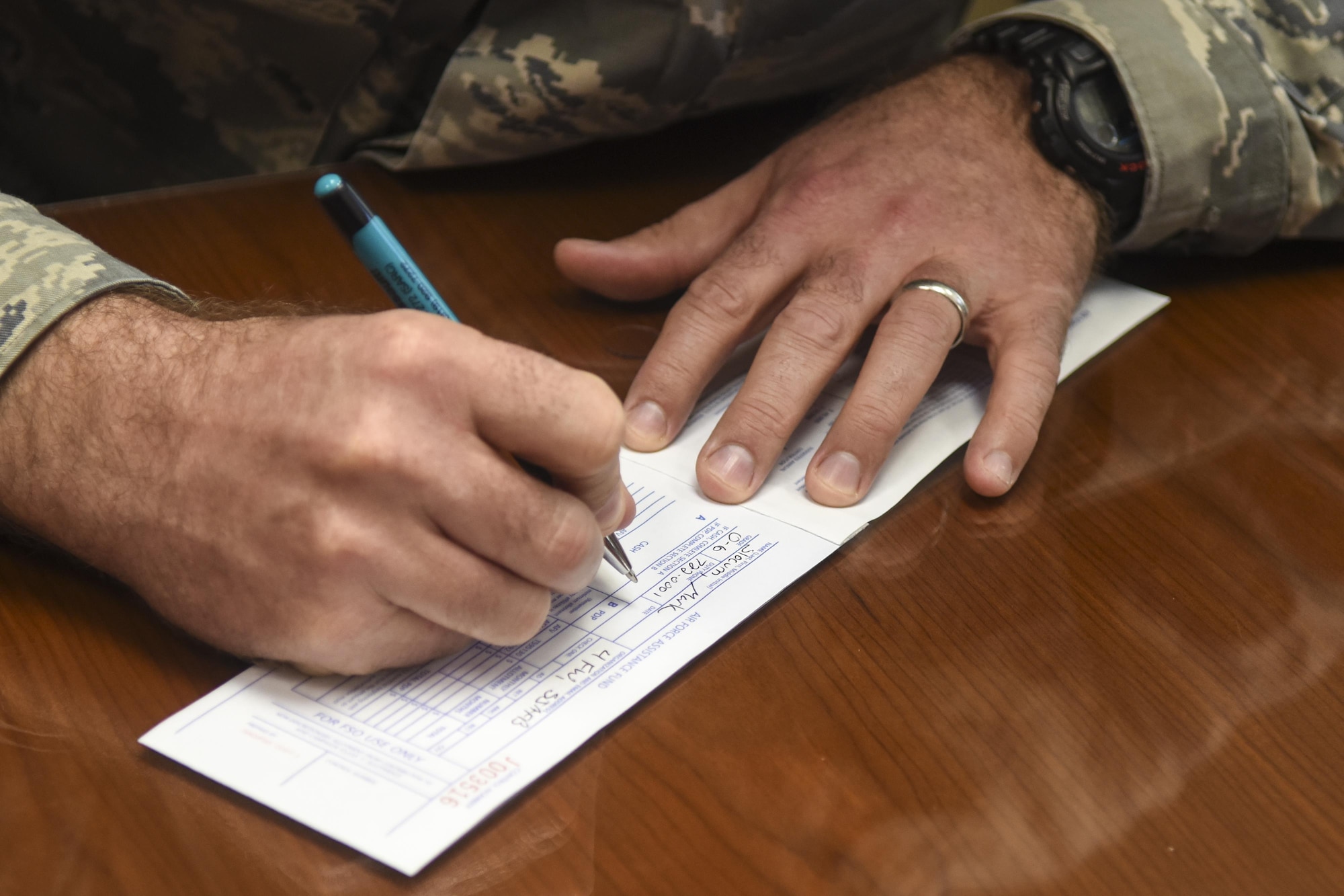 An Airman fills out a donation slip for the Air Force Assistance Fund for the 2017 AFAF Campaign. The AFAF is an Air Force-wide campaign that generates donations for four different charities: The Air Force Aid Society, Air Force Villages, Enlisted Air Force Villages, and the General and Mrs.Curtis E. Lemay Foundation. (U.S. Air Force photo/Airman Shawna L. Keyes)