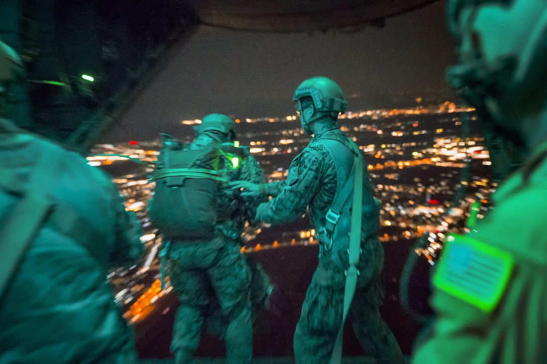 A Marine jumps from the back of an Air Force C-130H Hercules aircraft during jump week at Yokota Air Base, Japan, March 23, 2017. While the Marines practiced jumping, the Yokota aircrews practiced flight tactics and timed-package drops. Air Force photo by Yasuo Osakabe