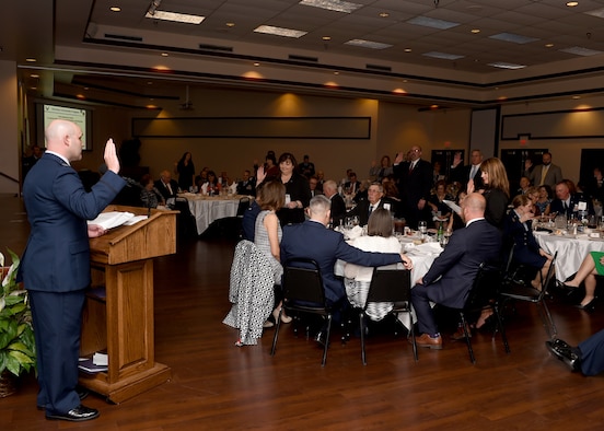 U.S. Air Force Col. Todd Hohn, 97th Air Mobility Wing commander leads new honorary commanders in their oath of service during the Honorary Commander Induction Ceremony March 24, 2017, Altus Air Force Base, Oklahoma.  Twenty-seven community members were inducted into the two-year program. (U.S. Air Force photo by Senior Airman Franklin R. Ramos/Released)