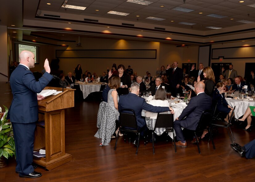 U.S. Air Force Col. Todd Hohn, 97th Air Mobility Wing commander leads new honorary commanders in their oath of service during the Honorary Commander Induction Ceremony March 24, 2017, Altus Air Force Base, Oklahoma.  Twenty-seven community members were inducted into the two-year program. (U.S. Air Force photo by Senior Airman Franklin R. Ramos/Released)