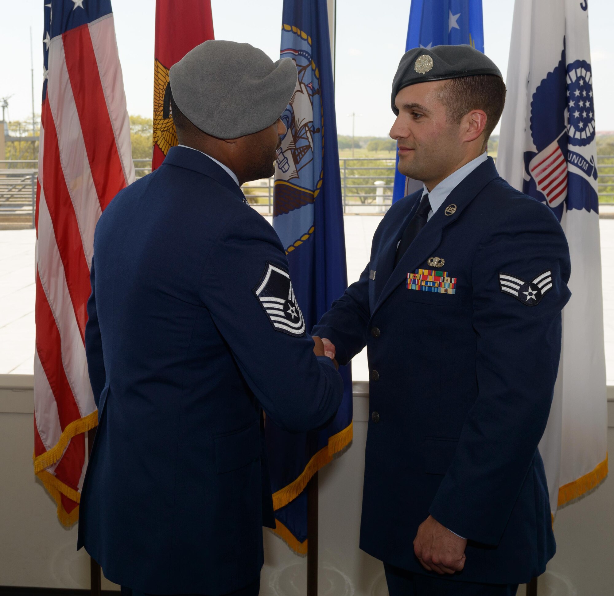 A Battlefield Airman congratulates Senior Airman Matthew James, 335th Training Squadron student, on graduating from the Special Operations Weather Apprentice Course at the Weather Training Complex, March 22, 2017, on Keesler Air Force Base, Miss. At his graduation James received his Gray Beret. (U.S. Air Force photo by Andre’ Askew)