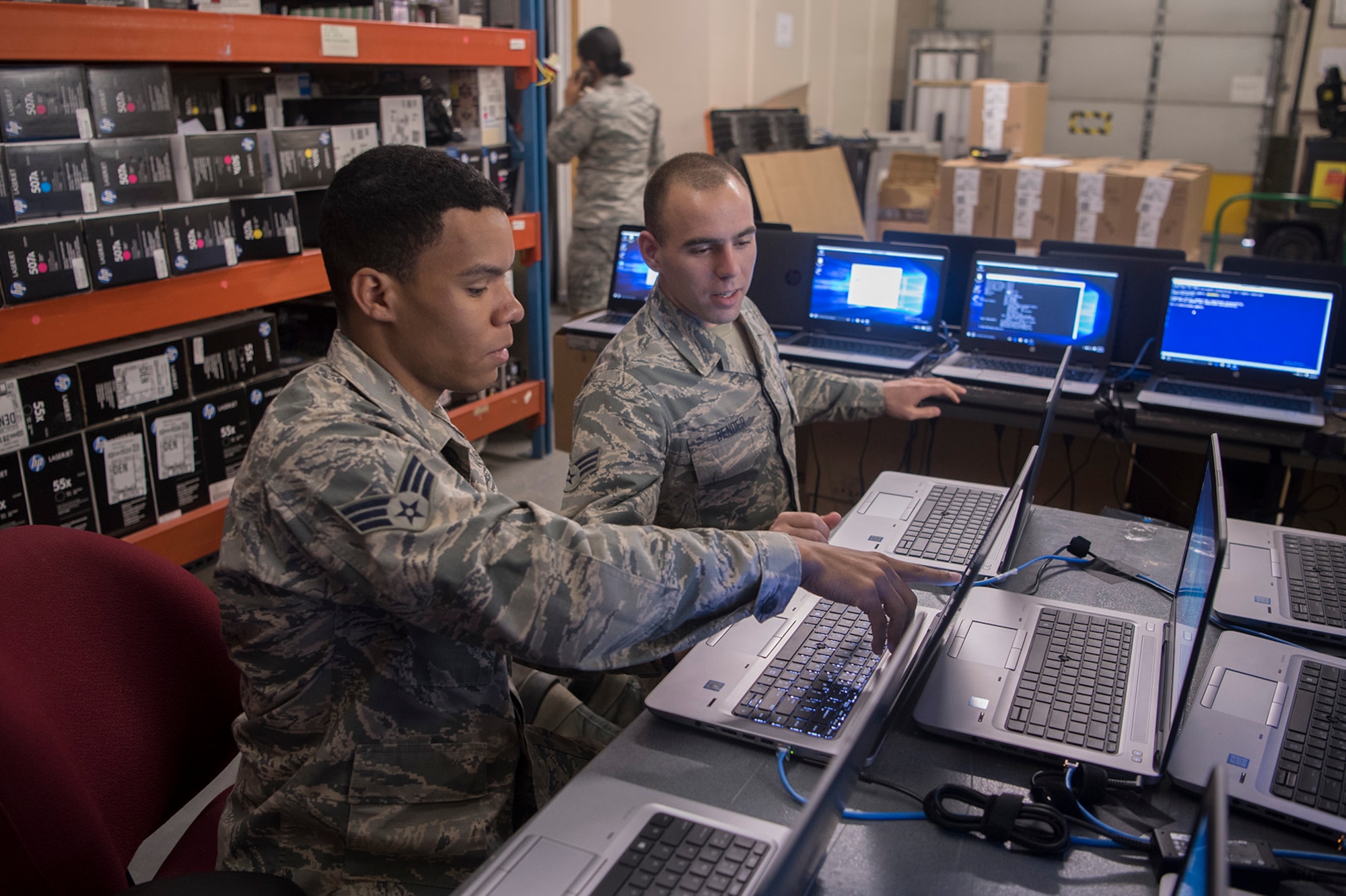 PETERSON AIR FORCE BASE, Colo. – Senior Airmen Jonathon Clayton, left, and Dylan Bender, 21st Communication Squadron client systems technicians, work together to bring new Windows 10 laptops into compliance with Air Force standards at Peterson Air Force Base, Colo., March 22, 2017. The Windows 10 roll out is part of a Department of Defense wide mandate to update all computers across all services. The 21st CS has been working extra shifts to ensure that mandate is met well ahead of schedule on April 1.  (U.S. Air Force photo by Steve Kotecki)