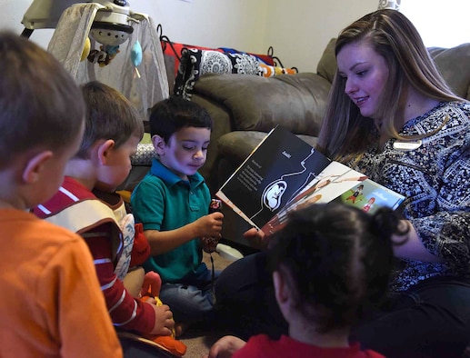 Liz Arrexi, 341st Force Support Squadron family child care home provider, right, reads a book to children March 24, 2017, at Malmstrom Air Force Base, Mont. Homes on base are licensed for only six children Air Force wide. (U.S. Air Force photo/Senior Airman Jaeda Tookes)