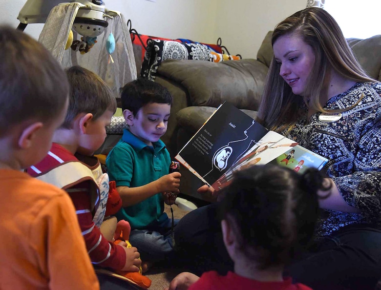 Liz Arrexi, 341st Force Support Squadron family child care home provider, right, reads a book to children March 24, 2017, at Malmstrom Air Force Base, Mont. Homes on base are licensed for only six children Air Force wide. (U.S. Air Force photo/Senior Airman Jaeda Tookes)