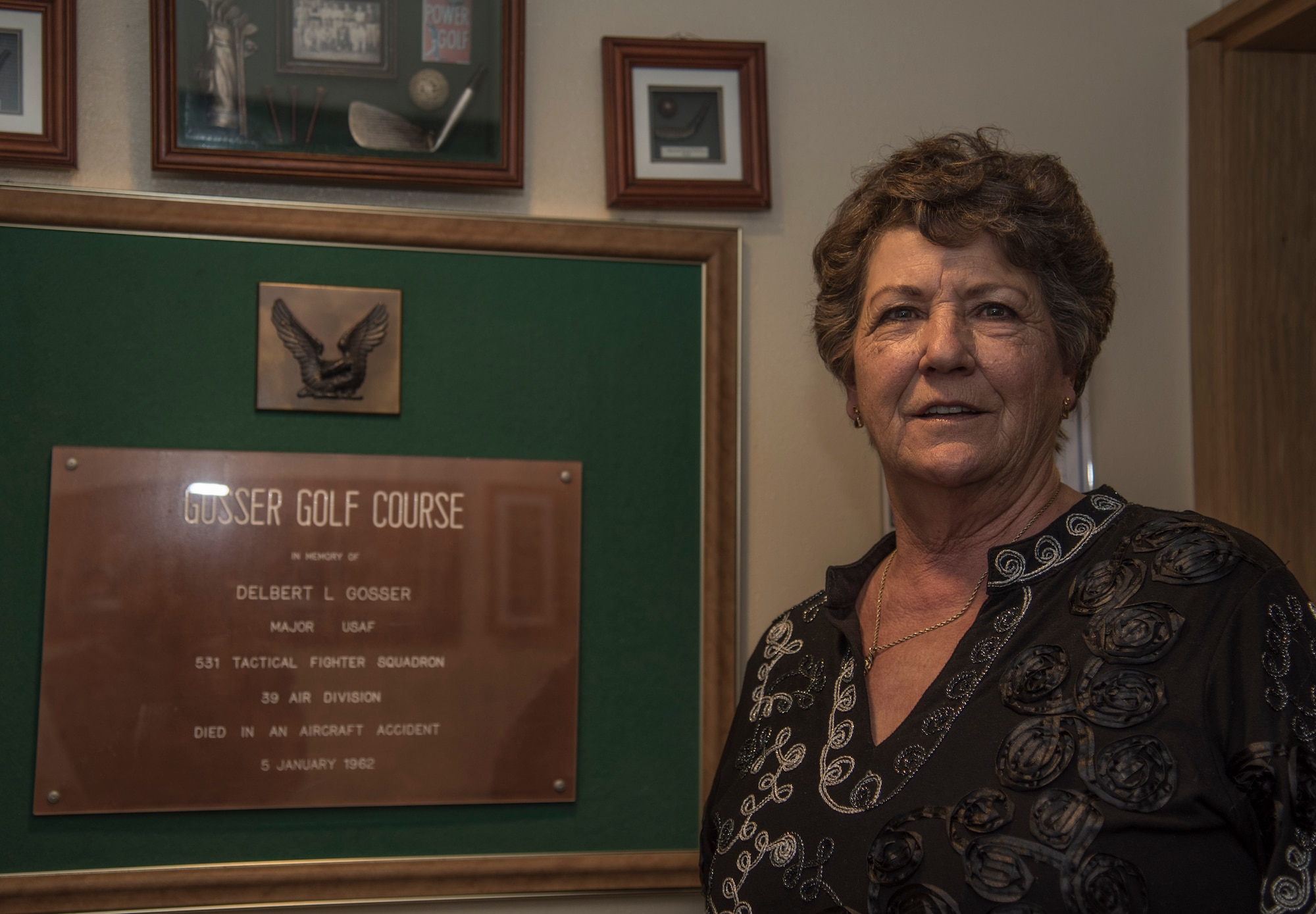 Debra Buchanan, daughter of Ret. Maj. Delbert Gosser, a former 531st Tactical Fighter Squadron pilot, poses with a plaque during her visit at the Gosser Golf Course at Misawa Air Base, Japan, March 27, 2017. Gosser died in a crash in the Pacific ocean near Misawa 10 minutes after take-off. (U.S. Air Force photo by Airman 1st Class Sadie Colbert)