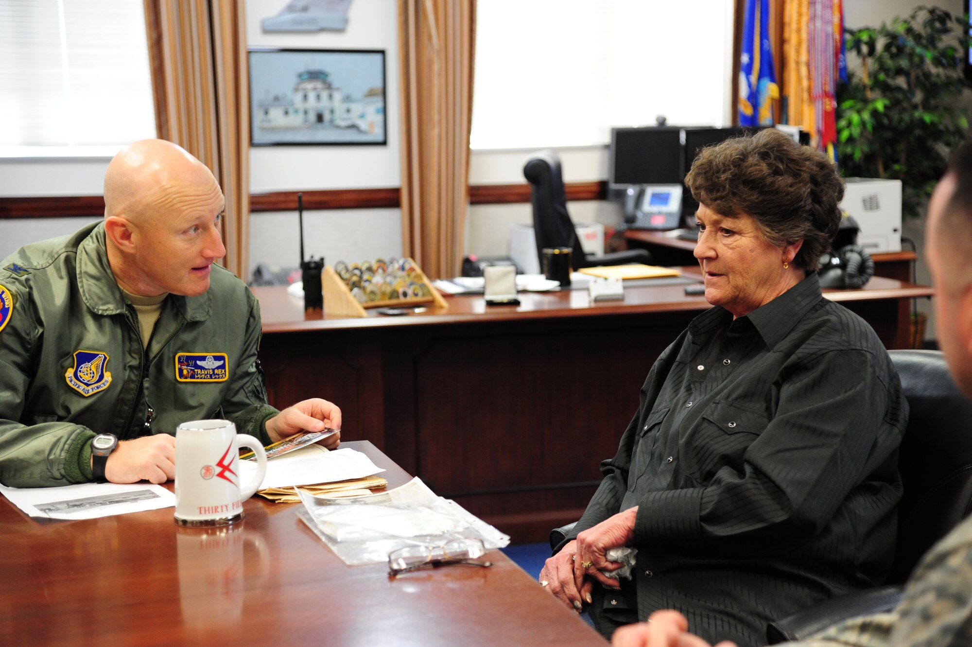 Col. Travis Rex, left, the 35th Fighter Wing vice commander, speaks with Debra Buchanan, right, daughter of Ret. Maj. Delbert Gosser, a former 531st Tactical Fighter Squadron pilot at Misawa Air Base, Japan, March 28, 2017. Buchanan gave Rex a gift of appreciation while she visited the Gosser Golf Course, named after her father who died in the Pacific Ocean near Misawa. (U.S. Air Force photo by Tech. Sgt. April Quintanilla)