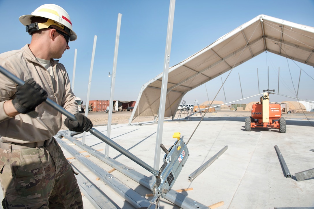 Air Force Staff Sgt. Ryan Mendenhall raises the arch of a dome shelter for the 407th Air Expeditionary Group at an undisclosed location in U.S. Central Command's area of operations, March 21, 2017.  Mendenhall is an electrical systems specialist assigned to the 577th Expeditionary Squadron. The shelter will provide 4,000 square feet of covered area to maintain vehicles in support of Operation Inherent Resolve. Air Force photo by Master Sgt. Benjamin Wilson