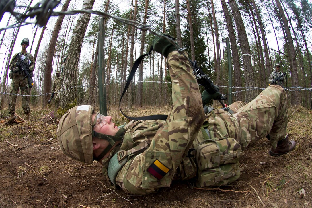 British army Pvt. Aaron Eastman maneuvers under concertina wire during Expert Field Medical Badge qualification in Grafenwoehr, Germany, March 21, 2017. Air Force photo by Tech. Sgt. Brian Kimball