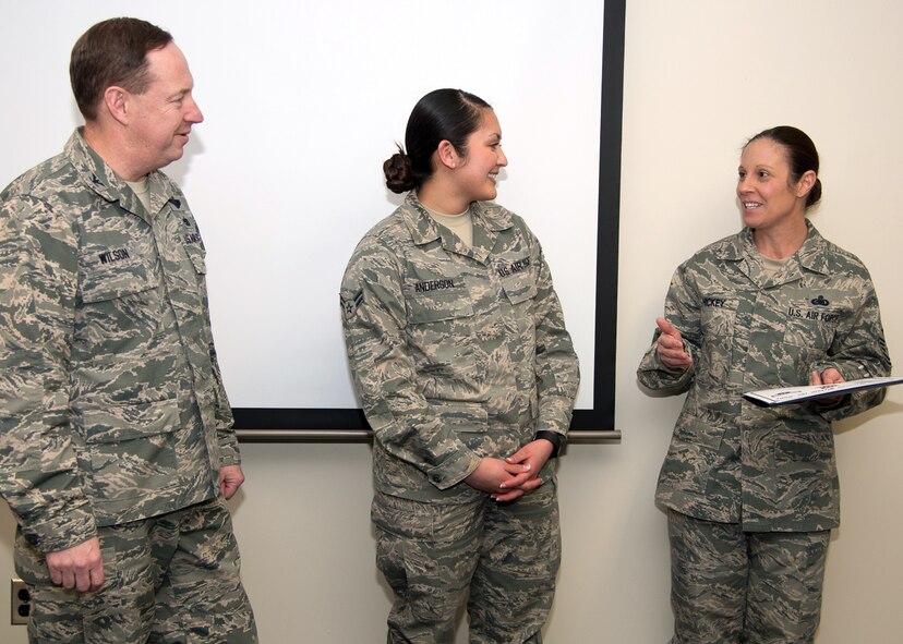 Command Chief Master Sgt. Patricia Hickey, right, and Col. Mark Wilson, Individual Mobilization Augmentee to the 66th Air Base Group commander, present a certificate to Airman 1st Class Michele Anderson, 66th Comptroller Squadron support staff, on her promotion through the below-the-zone promotion program. BTZ is a competitive early promotion program offered to those in the rank of airman first class. Also promoted was Airman 1st Class John Miller, a patrolman assigned to the 66th Security Forces Squadron. (U.S. Air Force photo by Mark Herlihy)