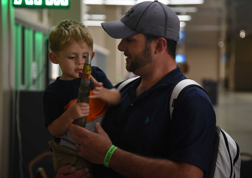 Kelly Csaszar Jr. and his son, Basin, learn about explosive ordinances from 22nd Civil Engineer Squadron Explosive Ordinance Disposal Airmen March 24, 2017 in Oklahoma City, Okla. Three EOD Airmen attended the For Inspiration and Recognition of Science and Technology Robotics Competition to educate competitors and attendees about the EOD mission. (U.S. Air Force photo/Airman 1st Class Erin McClellan)