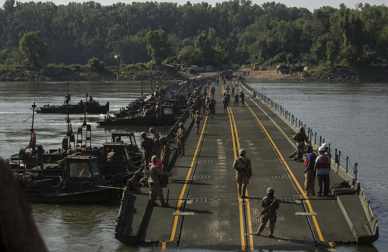 Marines with Bridge Company, 8th Engineer Support Battalion, Bridge Co. Bravo, 6th ESB and U.S. Army soldiers with 814th Multi-Roll Bridge Co. begin allowing vehicles to cross the continuous span bridge during Exercise River Assault on Fort Chaffee, July 19, 2016. The Marines spent two weeks operating Mk3 bridge erection boats and practicing connecting IRBs in preparation for the final exercise, which was a continuous IRB spanned across the Arkansas River. (U.S. Marine Corps photo by Cpl. Justin T. Updegraff)