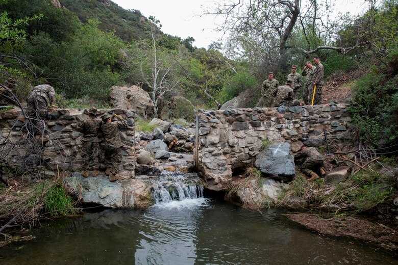 U.S. Marines with 1st Marine Logistics Group and U.S. Navy Sailors with Underwater Construction Team Two discuss which explosives they are going to use and how they will be placed to demolish a dam at Cleveland National Forest in Silverado, Calif., on March 21, 2017. The Marines will conduct dam demolition operations at Cleveland National Forest over the next two years to allow the land to return to its natural state. (U.S.Marine Corps photo by Lance Cpl. Adam Dublinske)