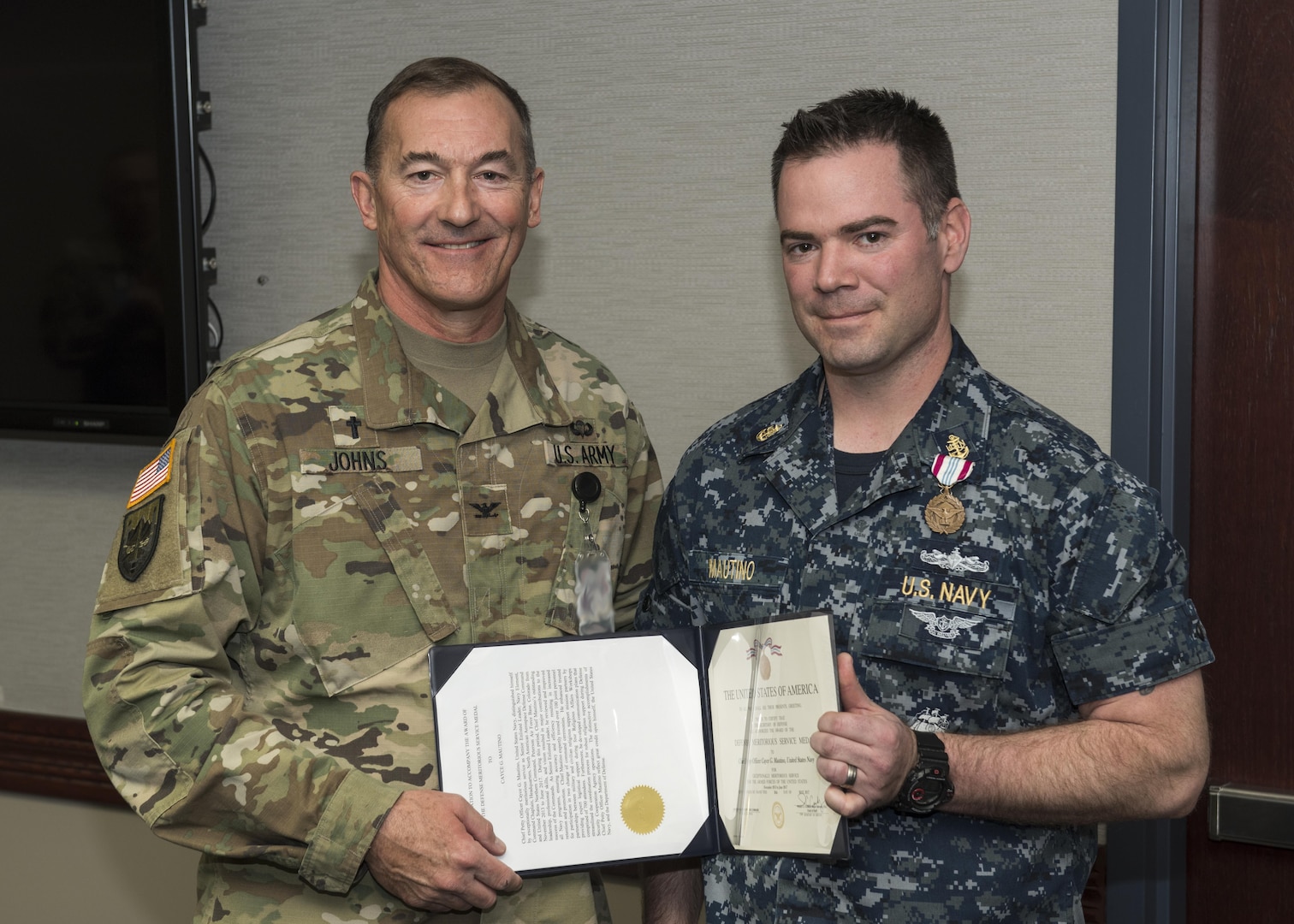 COL Jay Johns III, NORAD and USNORTHCOM command chaplain, presents the Defense Meritorious Service Medal to Chief Petty Officer Cayce Mautino, U.S. Navy. The NORAD and USNORTHCOM Office of the Command Chaplain at held a religious affairs workshop titled  "Embracing Complexity-Navigating Uncertainty" March 23, 2017. The three-day event focused on strengthening relationships and interoperability with military mission partners. Attendees included the National Guard, National Guard Bureau, the Royal Bahamas Defence Force Command Chaplain, Canadian Armed Forces Chaplain General Representative, NORAD & USNORTHCOM Region, and Component and Subordinate Command Chaplains.
