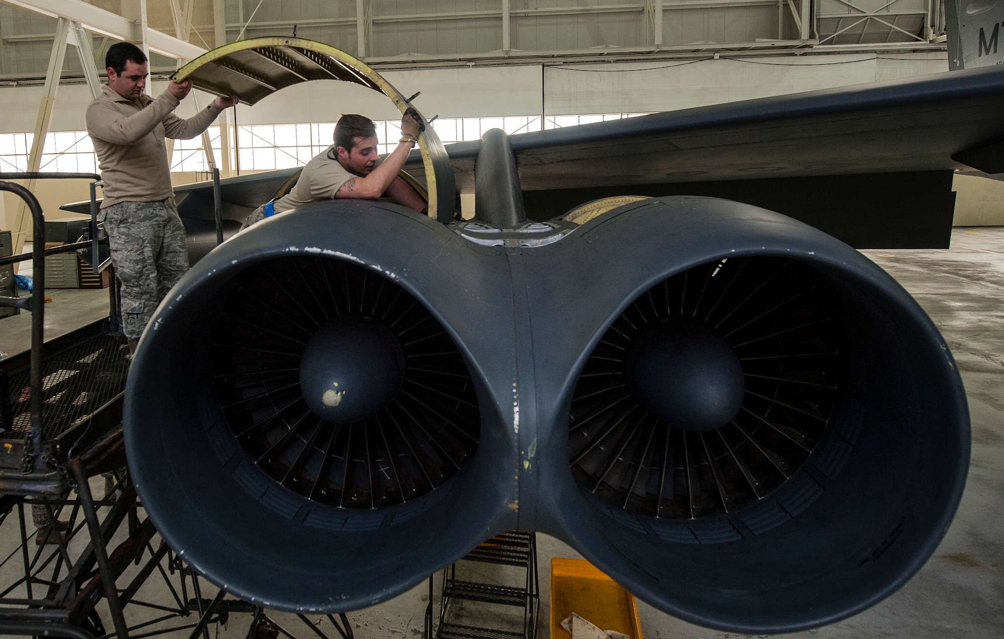 (From left) Senior Airman Allan Jungst and Staff Sgt. Alex Yount, 5th Maintenance Squadron crew chiefs, install an upper wrap cowling at Minot Air Force Base, N.D., March 20, 2017. The crew chiefs coordinate and perform aircraft maintenance to ensure all aircraft components are functioning properly. (U.S. Air Force photo/Airman 1st Class Jonathan McElderry)
