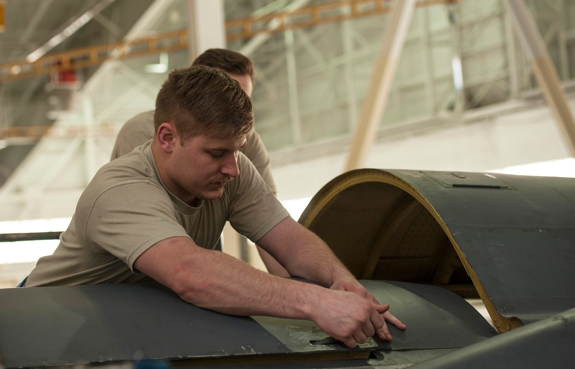 Senior Airman Shane Vandevelde, 5th Maintenance Squadron crew chief, closes an upper wrap cowling at Minot Air Force Base, N.D., March 20, 2017. During a phase inspection for 18 consecutive days, these maintainers wash, lubricate, inspect and fix all identified discrepancies on the B-52H Stratofortress. (U.S. Air Force photo/Airman 1st Class Jonathan McElderry)