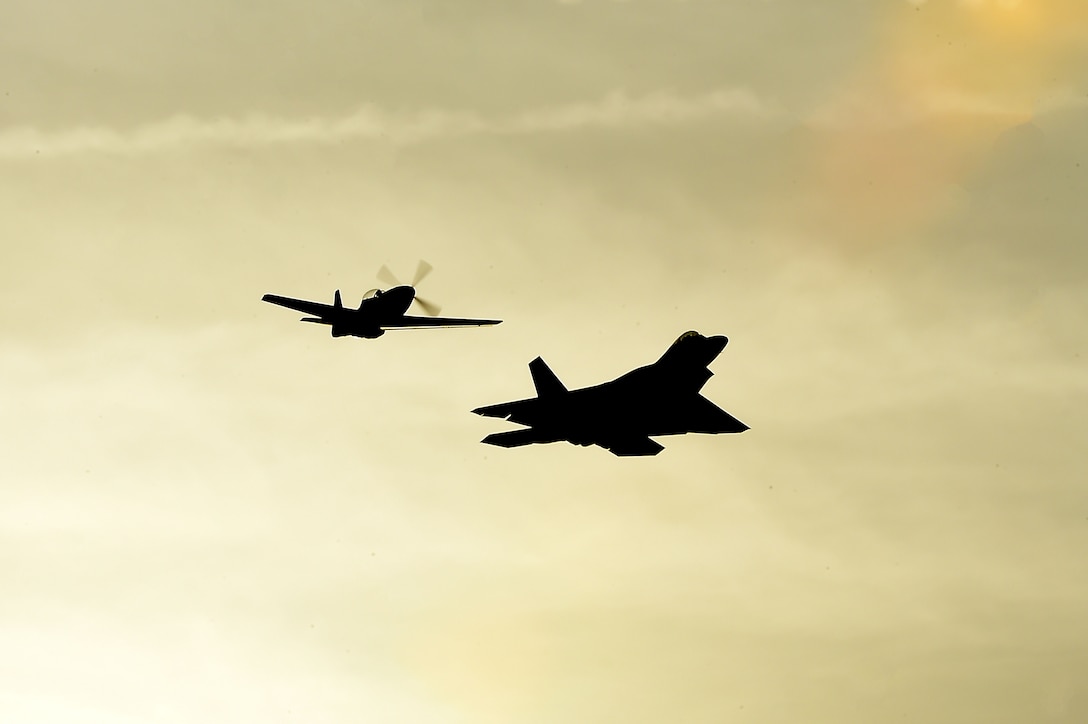 An F-22 Raptor and an P-51 Mustang perform a twilight show during the Wings Over Golden Isles Air Show in Brunswick, Ga., March 24, 2017. The duo performed a Heritage Flight, which is a performance of current fighter and attack aircraft flying with World War II, Korea and Vietnam era fighter aircraft. (U.S. Air Force photo/Senior Airman Kimberly Nagle)