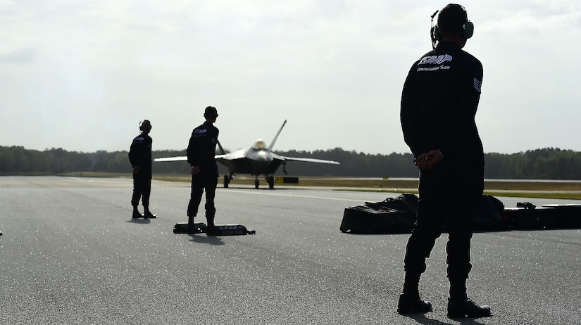 Members of the F-22 Raptor Demonstration Team wait for the arrival of the jets during the Wings Over Golden Isles Air Show in Brunswick, Ga., March 23, 2017. The F-22s  that were utilized during the show were assigned to the 95th Fighter Squadron at Tyndall Air Force Base, Fl. (U.S. Air Force photo/Senior Airman Kimberly Nagle)