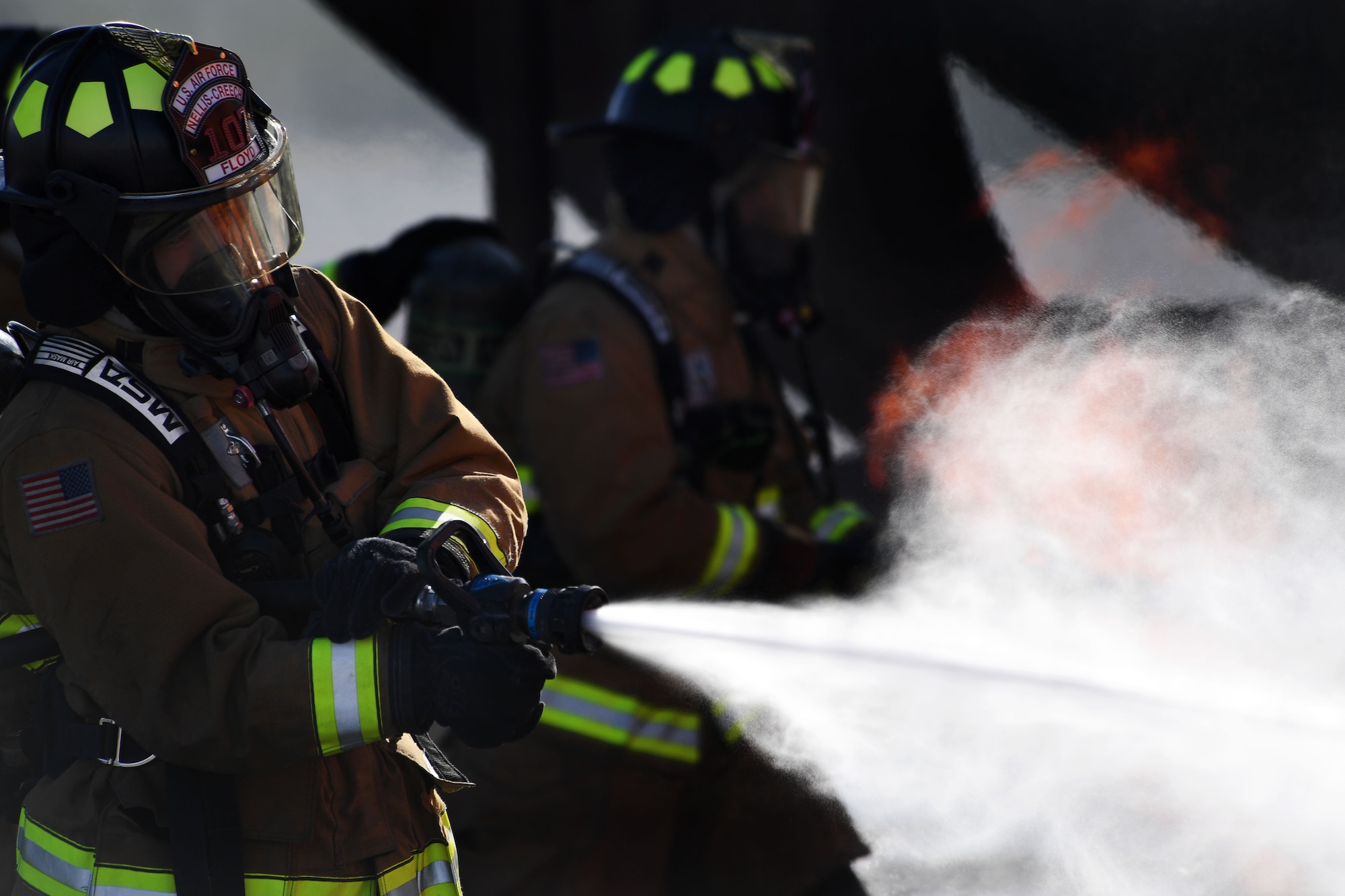 Airmen assigned to the 99th Civil Engineer Squadron Fire Protection Flight extinguish a controlled fire at Nellis Air Force Base, Nev. Airmen from Nellis and Creech Air Force Base completed an aircraft live burn exercise in order to stay current on their training. (U.S. Air Force photo/Airman 1st Class James Thompson) 