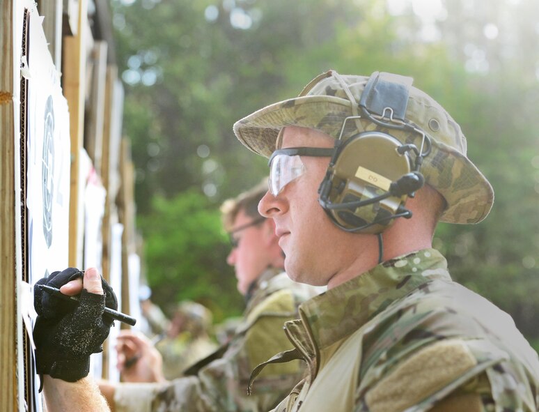 A combat controller adds up the points on his target at the Fire and Pistol Club on Hurlburt Field, Fla., March 29, 2017. (U.S. Air Force photo/Staff Sgt. Melanie Holochwost)