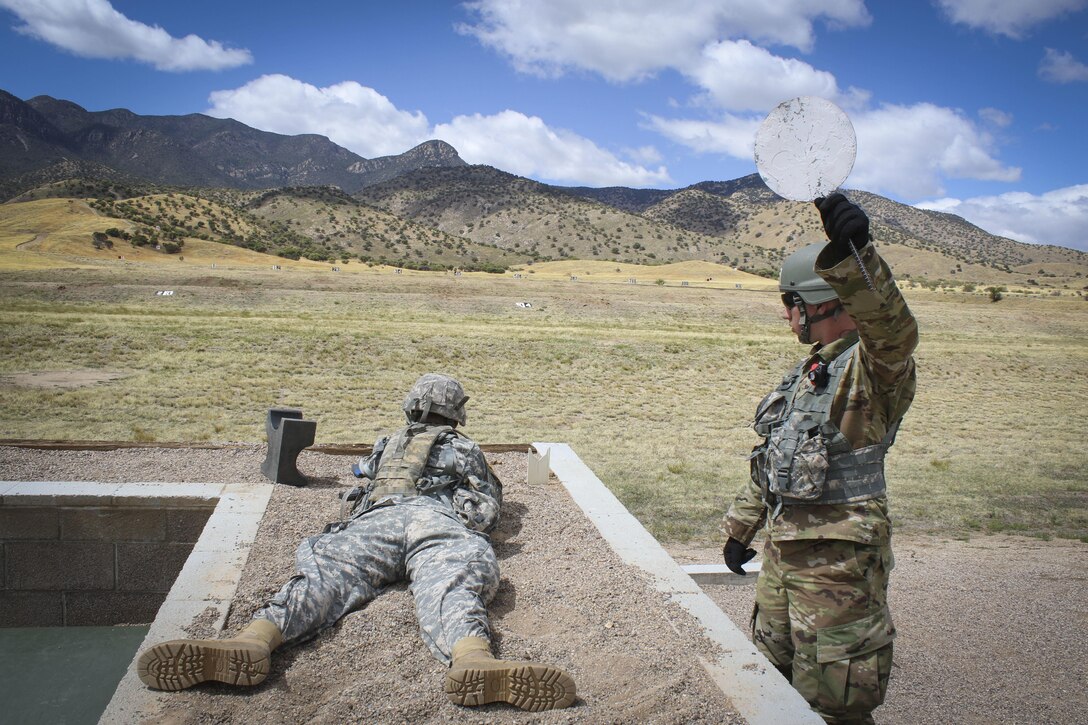 Army Reserve Sgt. Christopher Elam (right) a multi-channel transmission operator, assigned to Company C, 98th Expeditionary Signal Battalion, 335th Signal Command (Theater), gives the all clear signal to the control tower on a rifle qualification range as Spc. Josue Mendez, a information systems technician and native of Stockton, California, assigned to 319th Expeditionary Signal Battalion, 335th SC (T) prepares to fire a M16A2 rifle at targets downrange during a rifle qualification portion of the command's 2017 Best Warrior Competition at Fort Huachuca, Arizona, March 28.  (Official U.S. Army photo by Sgt. 1st Class Brent C. Powell)