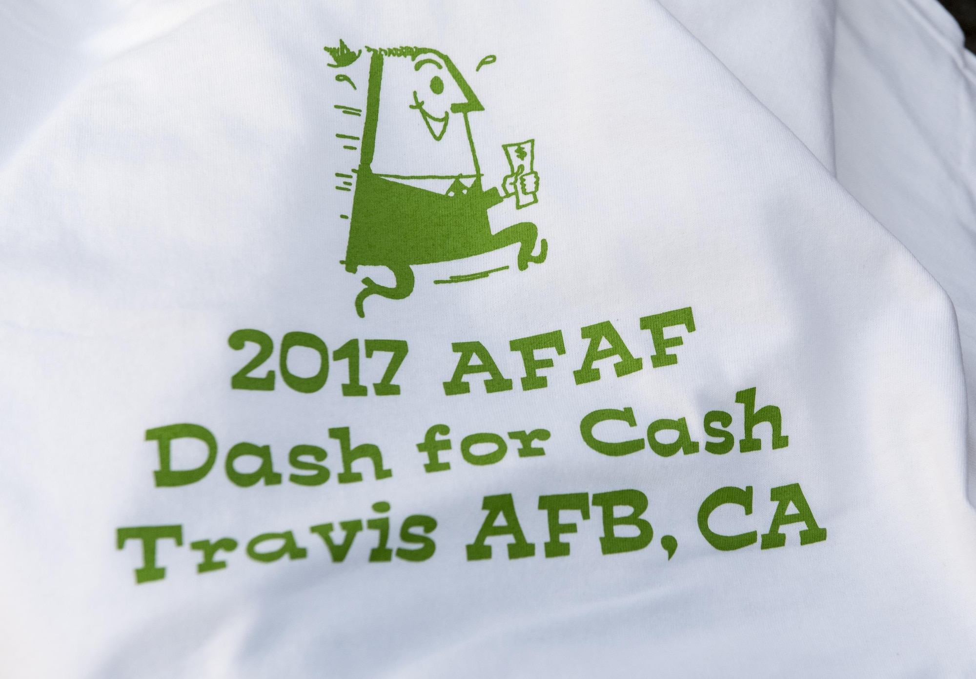 A t-shirt promoting the 2.5 mile fun run for the Air Force Assistance Fund (AFAF) kick off was handed out to registered runners, Mar. 27, 2017, Travis Air Force Base, Calif. More than 200 people participated in the event which was held to raise awareness about the AFAF mission; supporting Air Force families in need, covering active duty, retirees, reservists, guard, dependents, and surviving spouses. (U.S. Air Force photo/ Heide Couch)