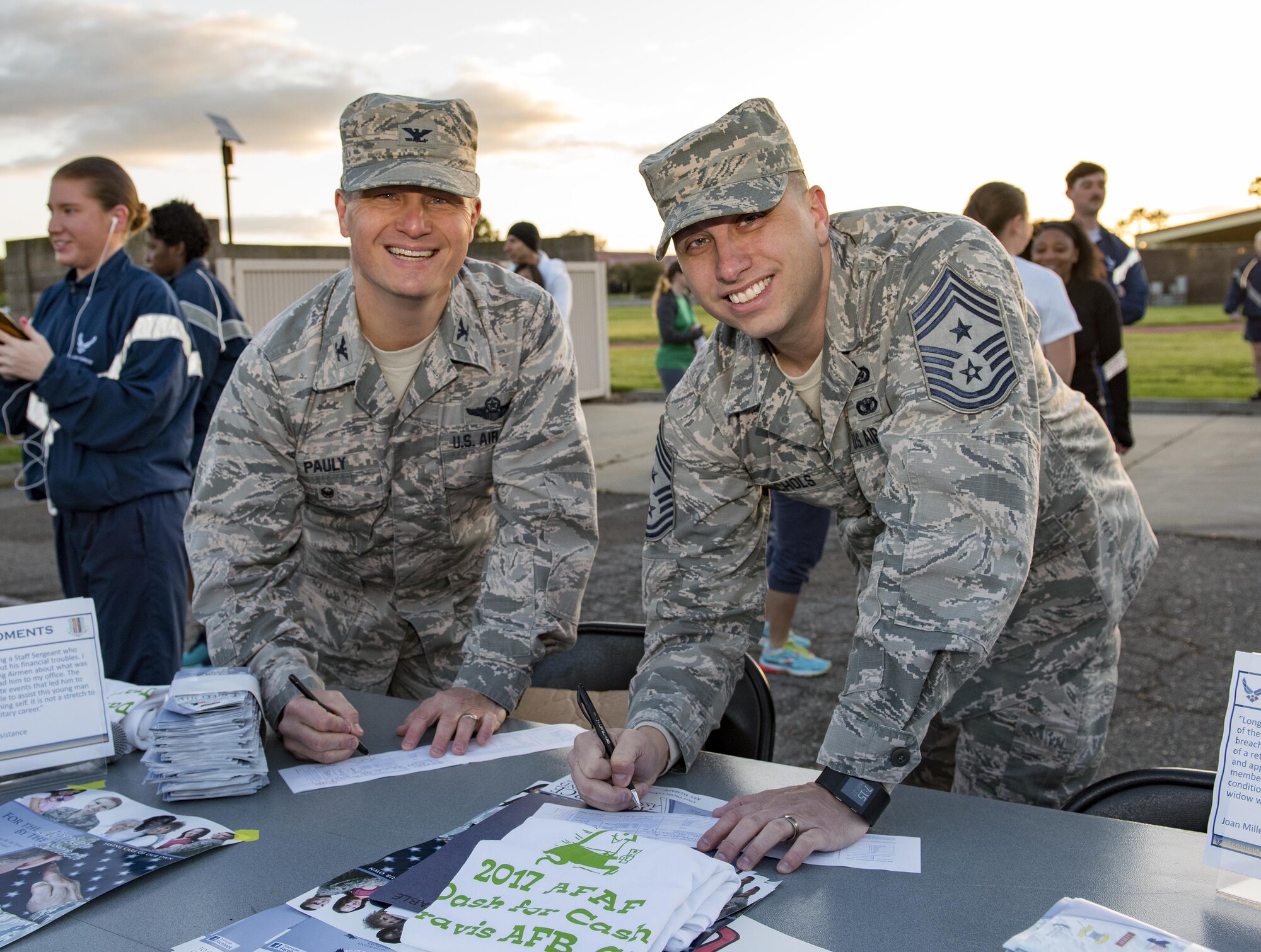 U.S. Air Force Col. Thomas Pauly, 60th Air Mobility Wing Vice commander and Chief Master Sgt. Steve Nichols, 60 AMW command chief, sign contribution pledges during the Air Force Assistance Fund (AFAF) kick off and fun run, Mar. 27, 2017, Travis Air Force Base, Calif. More than 200 people participated in the event which was held to raise awareness about the AFAF mission; supporting Air Force families in need, covering active duty, retirees, reservists, guard, dependents, and surviving spouses.(U.S. Air Force photo/ Heide Couch)