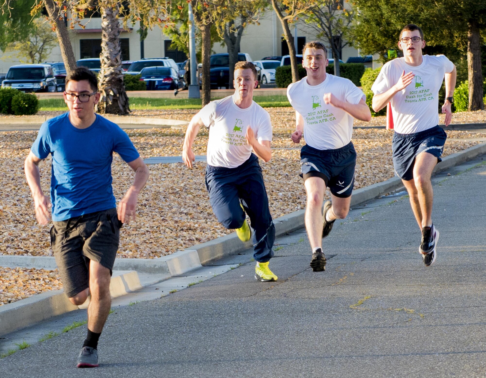 With a final burst of speed, runners approach the finish line of the 2.5 mile long Air Force Assistance Fund fun run, Mar. 27,2017, Travis Air force Base, Calif. More than 200 people participated in the event which was held to raise awareness about the AFAF mission; supporting Air Force families in need, covering active duty, retirees, reservists, guard, dependents, and surviving spouses. (U.S. Air Force photo/ Heide Couch)