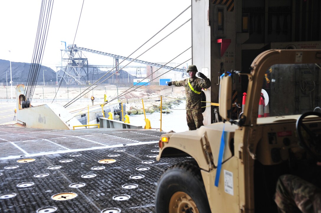 Spc. Loren Laws, motor transport operator, 227th Quartermaster Company, 129th Combat Sustainment Support Battalion, 101st Airborne Division Sustainment Brigade, out of Fort Campbell, Kentucky, directs vehicles off a cargo ship at Gdansk, Poland, March 28. Seventeen active duty, U.S. Army Reserve and Army national guard support units arrived to Poland to support Atlantic Resolve under the 16th Sustainment Brigade.  (U.S. Army photo by Sgt. 1st Class Jacob A. McDonald, 21st Theater Sustainment Command Public Affairs)