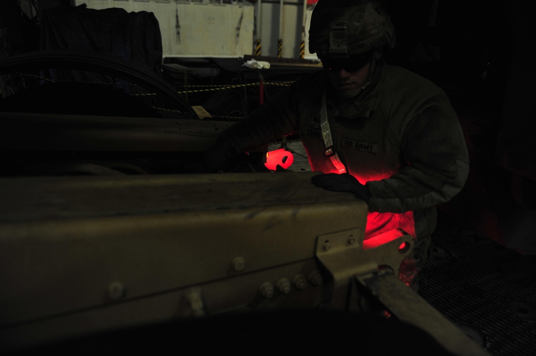 Spc. Alex Stamm, motor transport operator, 32nd Composite Truck Company, 4th Sustainment Brigade, 4th Infantry Division, adjusts the tires on his heavy equipment transporter in preparation for driving it off a cargo ship at Gdansk, Poland, March 28. Seventeen active duty, U.S. Army Reserve and Army national guard support units arrived to Poland to support Atlantic Resolve under the 16th Sustainment Brigade.  (U.S. Army photo by Sgt. 1st Class Jacob A. McDonald, 21st Theater Sustainment Command Public Affairs)