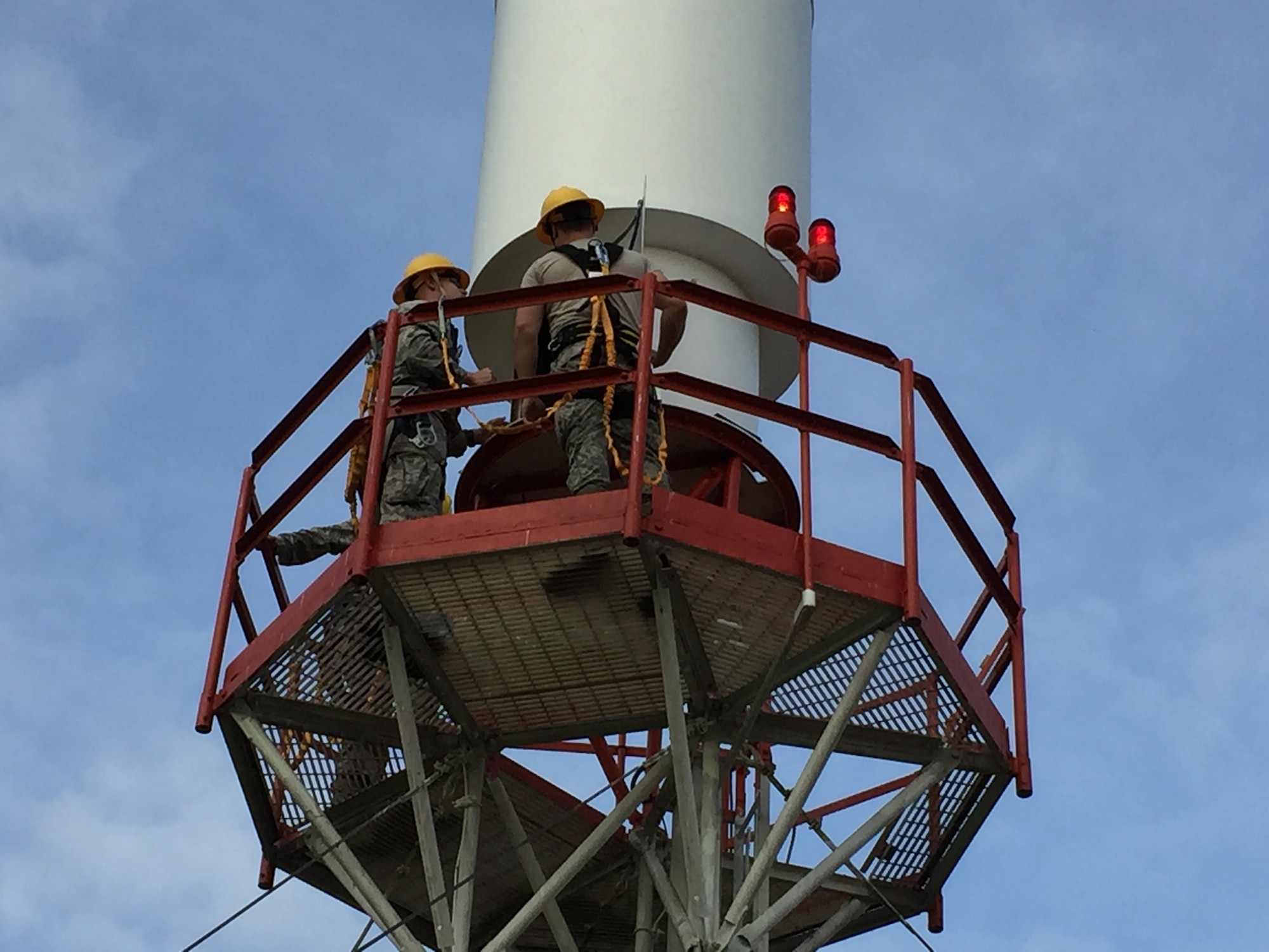 Senior Airmen Erik Maxey and Trae Watts, 375th Operational Support Squadron airfield systems technicians, climb a tactical air navigation system mast to work on the atennae. Airfield systems technicians perform preventative maintenance on the TACAN annually.