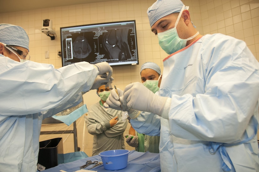 Army Maj. (Dr.) E’Stephan Garcia, orthopedic sports medicine surgeon assigned to William Beaumont Army Medical Center, Fort Bliss, Texas, prepares a new Food and Drug Administration-approved implant for fitting during the Defense Department’s first knee cartilage surgery of its kind, Feb. 9, 2017. The implant provides faster treatments, reduced impact and an additional treatment option for injuries that previously may have been treated with total or partial knee replacement. Army photo Marcy Sanchez