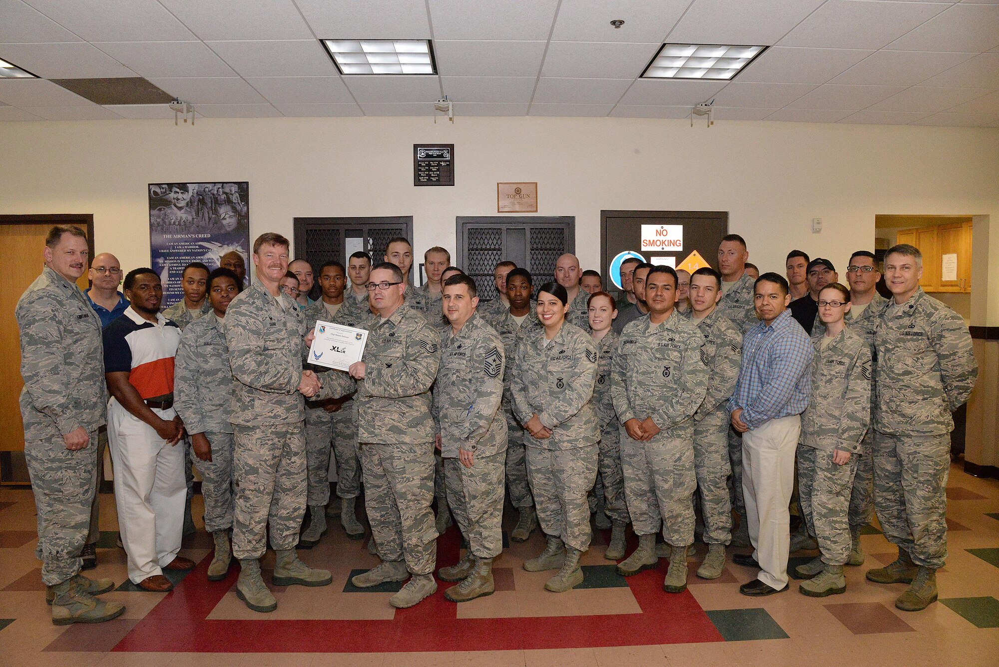 Staff Sgt. Shaun Jackson, 47th Security Forces Squadron unit training section NCO in charge (center), accepts the “XLer of the Week” award from Col. Thomas Shank, 47th Flying Training Wing commander (left), and Chief Master Sgt. George Richey, 47th FTW command chief (right), on Laughlin Air Force Base, Texas, March 22, 2017. The XLer is a weekly award chosen by wing leadership and is presented to those who consistently make outstanding contributions to their unit and Laughlin. (U.S. Air Force photo/Airman 1st Class Daniel Hambor)