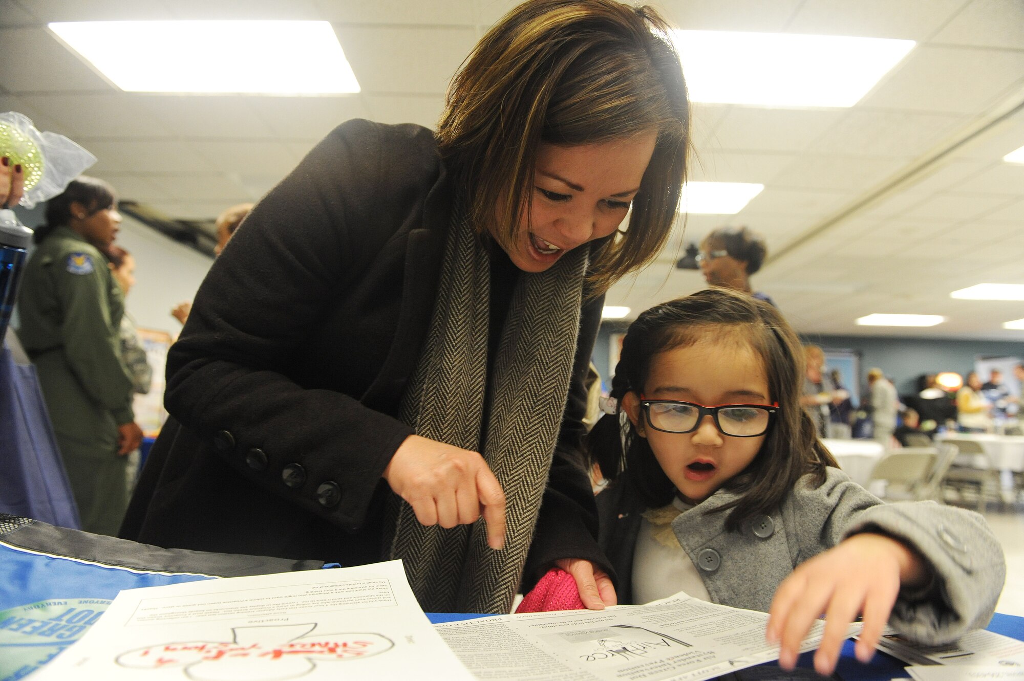 Fritzie Shinohara, a key spouse, and her daughter, Chloe, 4, visit the Green Dot booth at a women's resiliency fair March 23 at Scott Air Force Base. Green Dot is an innitiative aimed at preventing power-based violence among Air Force personnel. Visitors to the booth were encouraged to fill out ways to reduce violence. (U.S. Air Force photo by Tech. Sgt. Maria Castle)