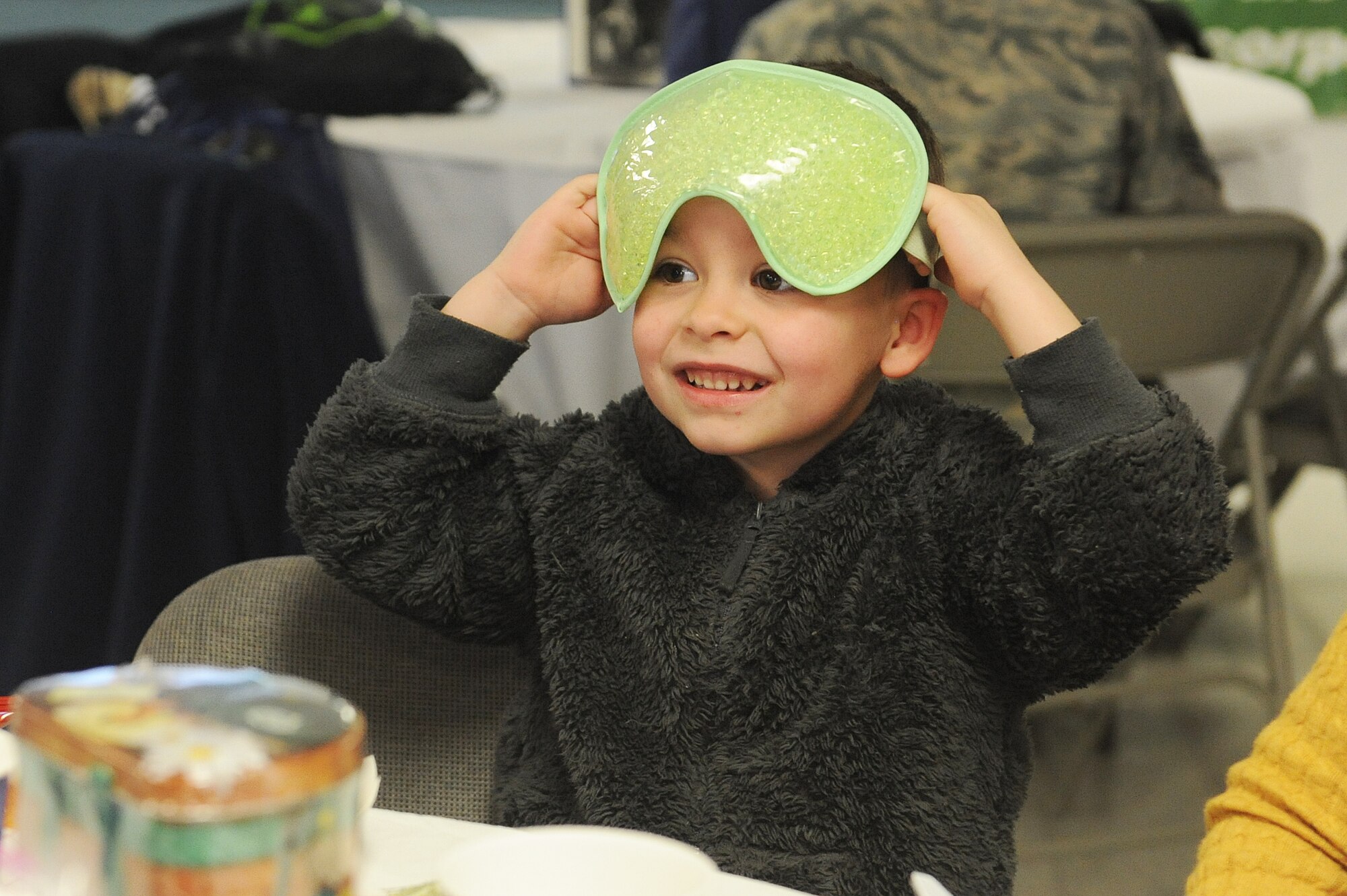 Lucas Dowell, 4, puts on an eye mask during a women's resiliency fair at Scott Air Force Base March 23.  The family-friendly event had informational booths from agencies focusing on mental, physical, spiritual and emotional health of women. The stations had promotional products and gifts, which visitors were able to take with them. (U.S. Air Force photo by Tech. Sgt. Maria Castle)