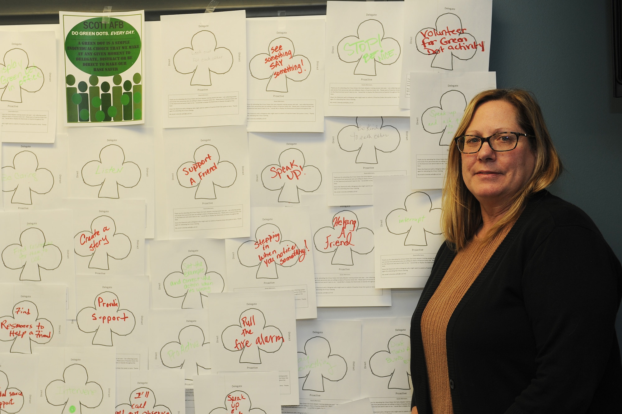Brenda Wells, 375th Air Mobility Wing primary prevention of violence specialist, works at a Green Dot information booth March 23 at Scott Air Force Base. Green Dot is an innitiative aimed at preventing power-based violence among Air Force personnel, and it focuses on "Red Dots," a decision someone makes to assault or abuse someone else, and "Green Dots," a decision someone makes to react or prevent that from happening. The emphasis of the program is less about reporting crimes when they happen and more about creating a climate where the situations wouldn't happen in the first place. Visitors to the booth were encouraged to fill out ways to reduce violence, which were taped to the wall for others to see. (U.S. Air Force photo by Tech. Sgt. Maria Castle)