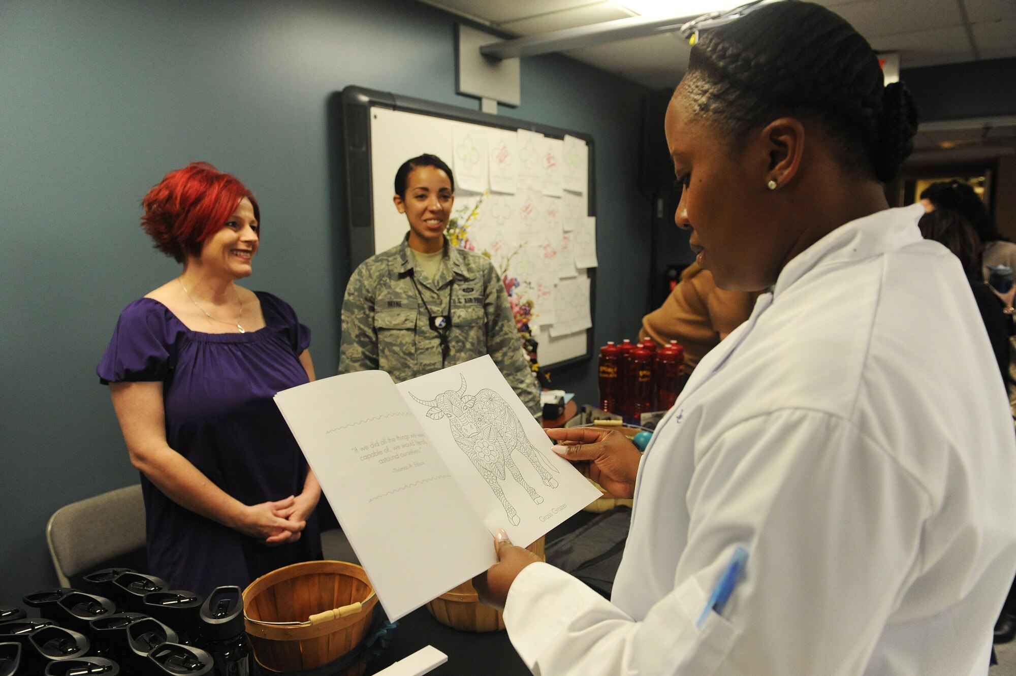 Tech. Sgt. Jeterria Thompson, 54th Airlift Squadron flight attendant, looks at a coloring book at the Sexual Assault Prevention and Response information booth at a women's resiliency fair March 23 at Scott Air Force Base. SAPR office representatives said coloring books can be used to reduce their clients' stress levels following a sexual assault or during an investigation. (U.S. Air Force photo by Tech. Sgt. Maria Castle)