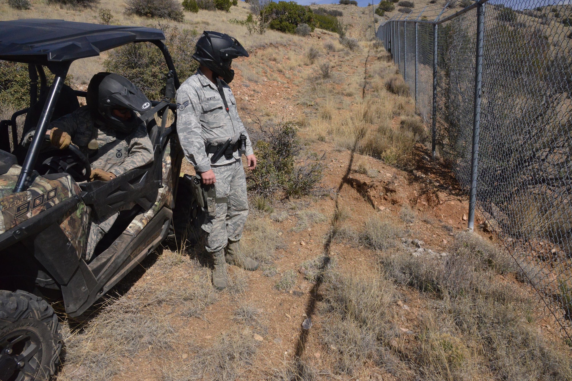 Staff Sgt. Bridget Skinner, left, and Senior Airman Jason Newsom check the Kirtland Air Force Base fence line in a remote area using one of the 377th Security Forces Squadron’s new Razor all-terrain vehicles. SFS conducts the patrols around the perimeter randomly each shift. (U.S. Air Force Photo/Senior Airman Chandler Baker) 