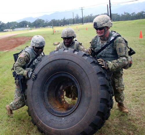 Sgt. Shannon Leftwich, Sgt. Todd Kelly and Sgt. Dylon Dibble, from the 95th Engineer Company (Sapper), 84th Engineer Battalion, flip a 400 pound Heavy Expanded Mobility Tactical Truck tire (HEMTT) during the 'Never Daunted' Best Squad Competition, March 2017. 