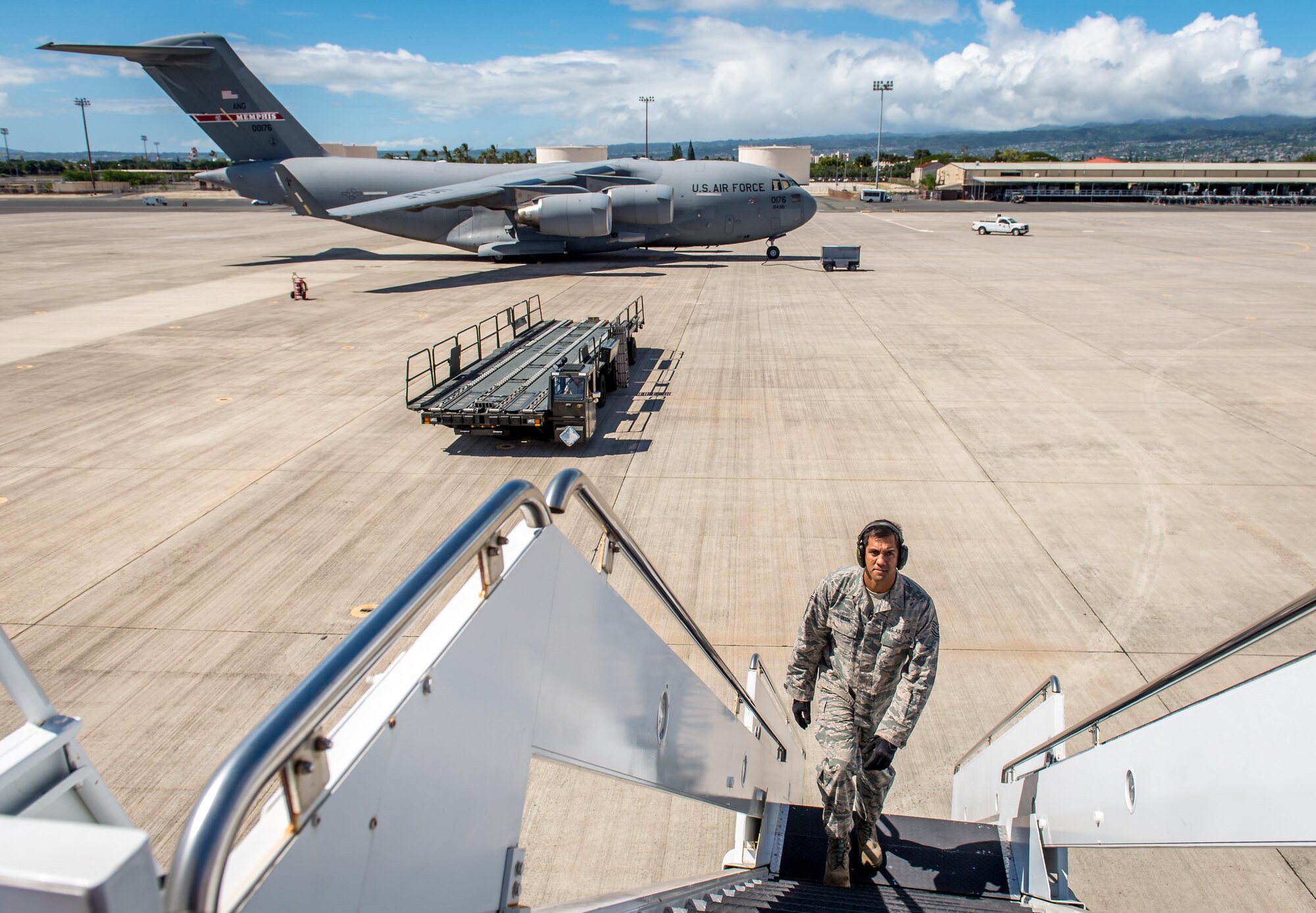 Then Tech. Sgt. Alfred Van Gieson, now Master Sgt., climbs the mobile steps leading to a C-135 waiting to transfer cargo at the 48th Aerial Port Squadron, 624th Regional Support Group, Joint Base Pearl Harbor-Hickam, Oahu, Hawaii, Aug 13, 2016. Van Gieson, an Air Force reservist, is a veteran of Operation Iraqi Freedom, a world champion outrigger, or Va'a, paddler and the coach at the Leeward Kai Canoe Club in Nanakuli, Oahu, which was founded by his grandparents. (U.S. Air Force photo by J.M. Eddins Jr.)