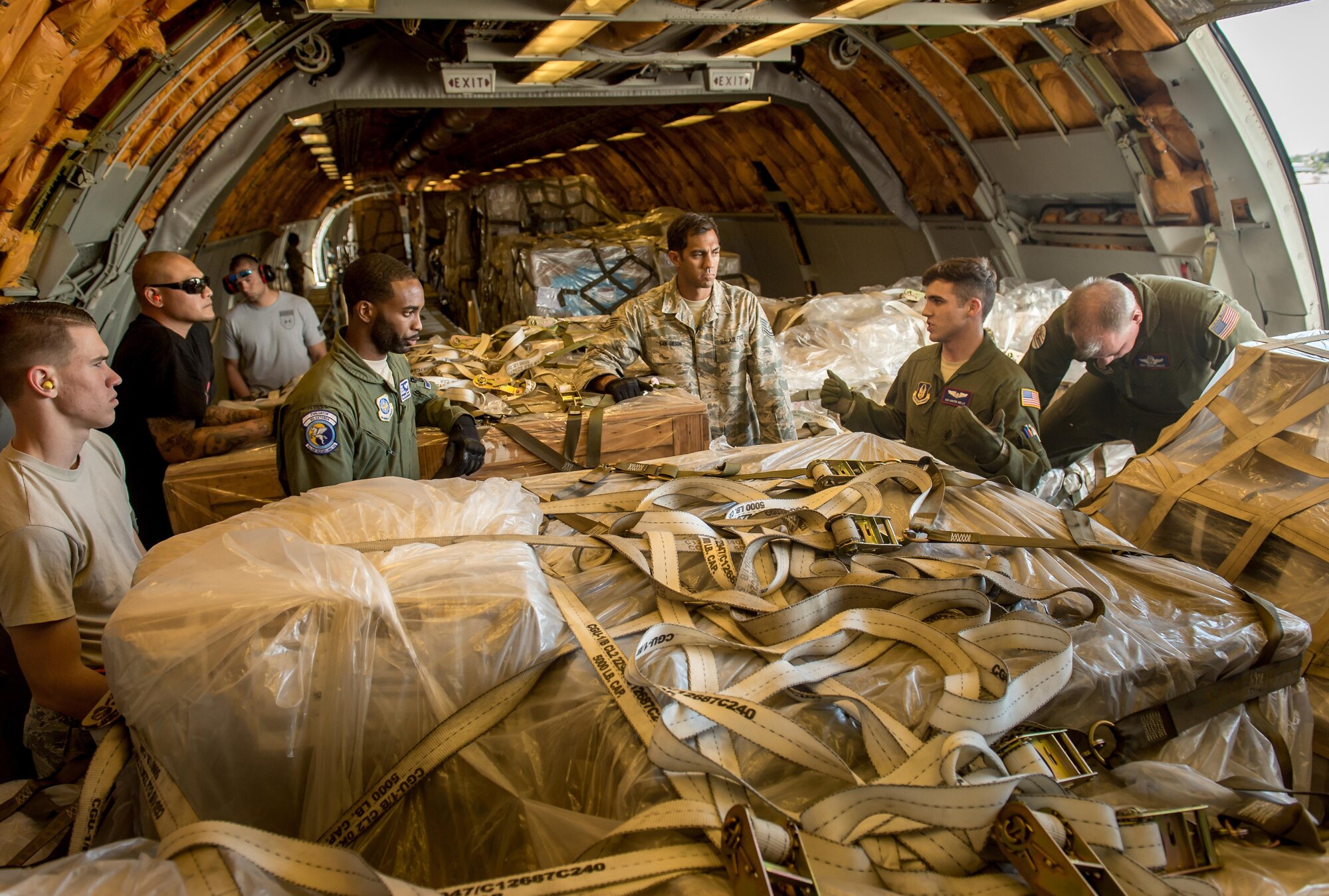 Then Tech. Sgt. Alfred Van Gieson, now Master Sgt., listens to a crew chief briefing before unloading cargo from a C-135 at Joint Base Pearl Harbor-Hickam, Oahu, Hawaii, Aug 13, 2016. Van Gieson, an Air Force reservist with 48th Aerial Port Squadron, 624th Regional Support Group, Joint Base Pearl Harbor-Hickam, is a veteran of Operation Iraqi Freedom, a world champion outrigger, or Va'a, paddler and the coach at the Leeward Kai Canoe Club in Nanakuli, Oahu, which was founded by his grandparents. (U.S. Air Force photo by J.M. Eddins Jr.)