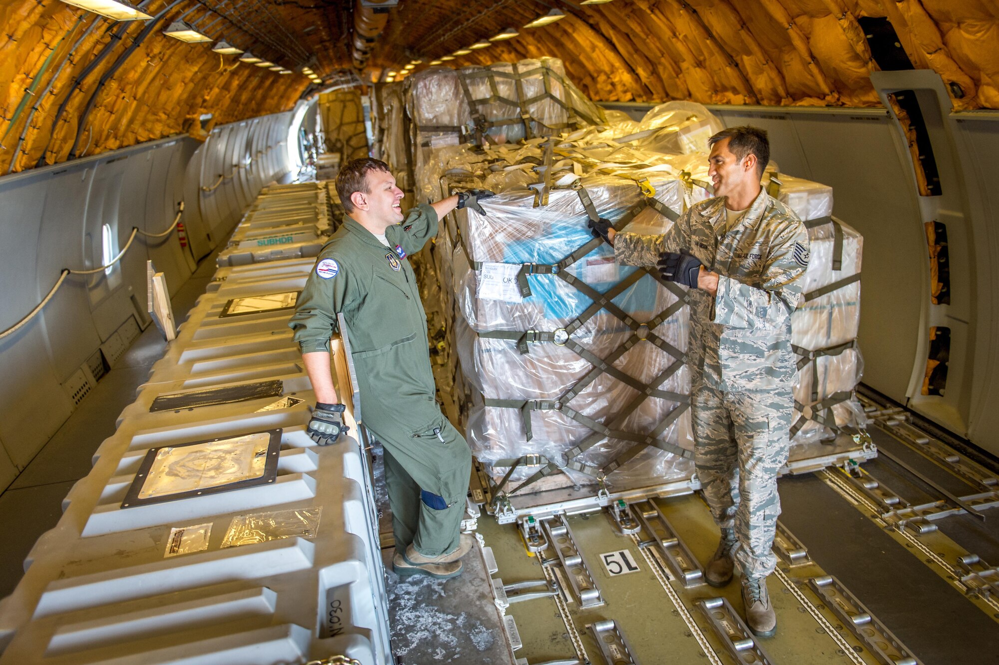 Then Tech. Sgt. Alfred Van Gieson, now Master Sgt., talks with Staff Sgt. Steve Zoppo, a boom operator with the 79th Air Refueling Squadron, on a C-135 waiting to transfer cargo at Joint Base Pearl Harbor Hickam, Oahu, Hawaii, Aug 13, 2016. Van Gieson, an Air Force reservist, is a veteran of Operation Iraqi Freedom, a world champion outrigger, or Va'a, paddler and the coach at the Leeward Kai Canoe Club in Nanakuli, Oahu, which was founded by his grandparents. (U.S. Air Force photo by J.M. Eddins Jr.)