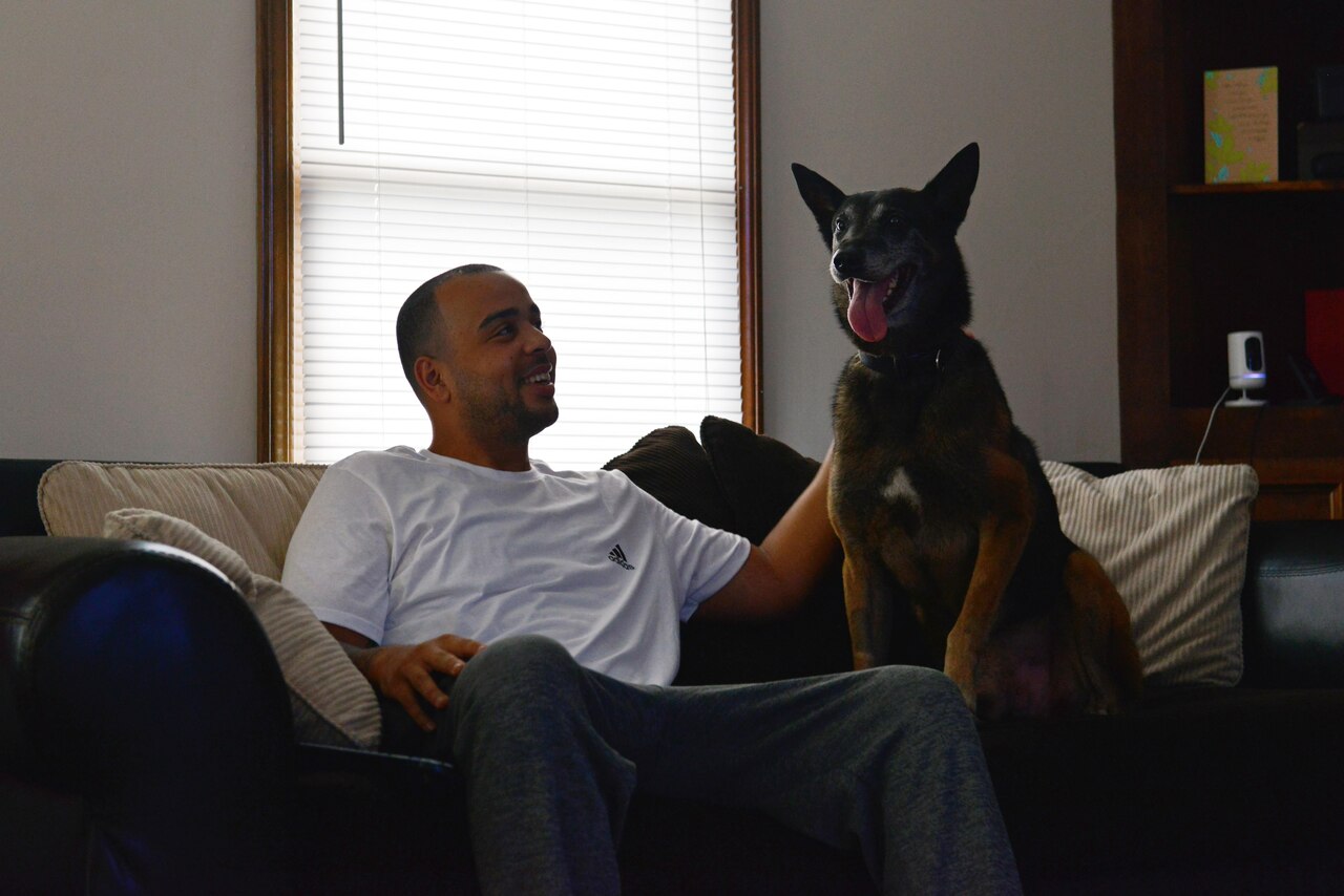 U.S. Air Force Staff Sgt. Anthony Despins, 20th Security Forces military working dog (MWD) handler, pets his dog, Jony, at his home in Sumter, S.C., March 22, 2017. Despins adopted Jony, his first MWD, after the dog retired due to a compressed disc in his spine. (U.S. Air Force photo by Airman 1st Class Destinee Sweeney)