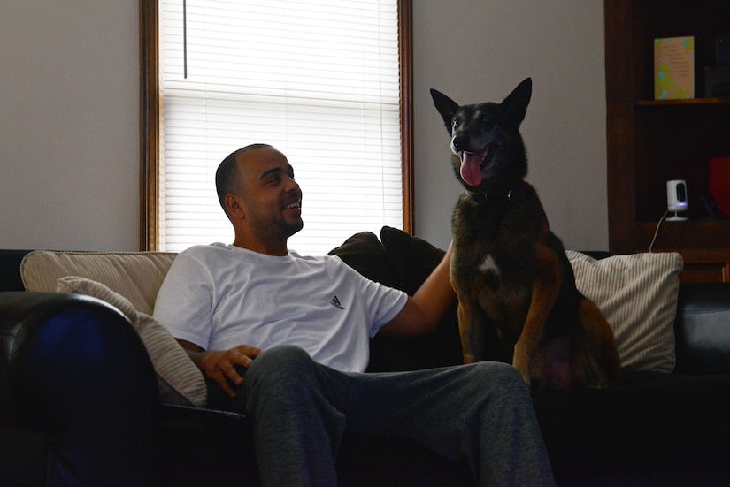 U.S. Air Force Staff Sgt. Anthony Despins, 20th Security Forces military working dog (MWD) handler, pets his dog, Jony, at his home in Sumter, S.C., March 22, 2017. Despins adopted Jony, his first MWD, after the dog retired due to a compressed disc in his spine. (U.S. Air Force photo by Airman 1st Class Destinee Sweeney)
