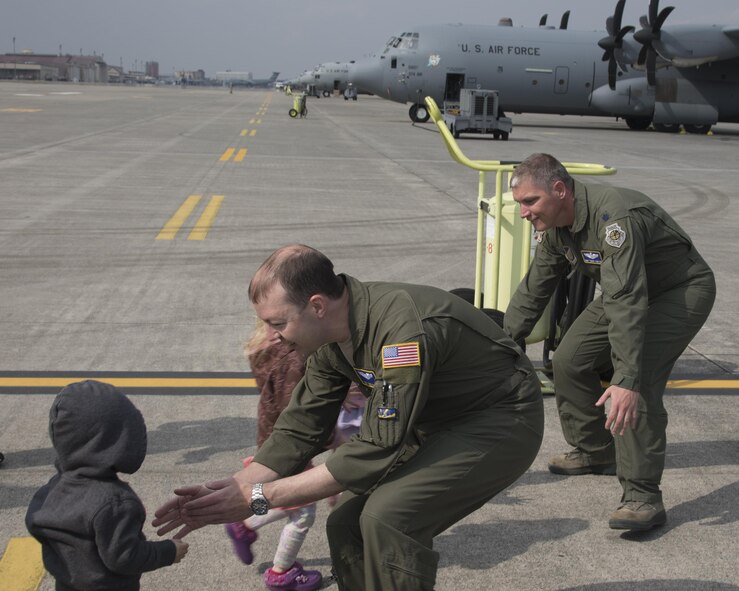 (Left to right) Tech. Sgt. Michael McArty, 374th Operations Group C-130 standardization and evaluation loadmaster, and Lt. Col. Robert Cureton, 374th Airlift Wing C-130J pilot, greet their children after landing at Yokota Air Base, Japan, March 29, 2017. This is the second C-130J delivered from Lockheed Martin, less than a month after the first was delivered March 6th. (U.S. Air Force photo by Yasuo Osakabe) 